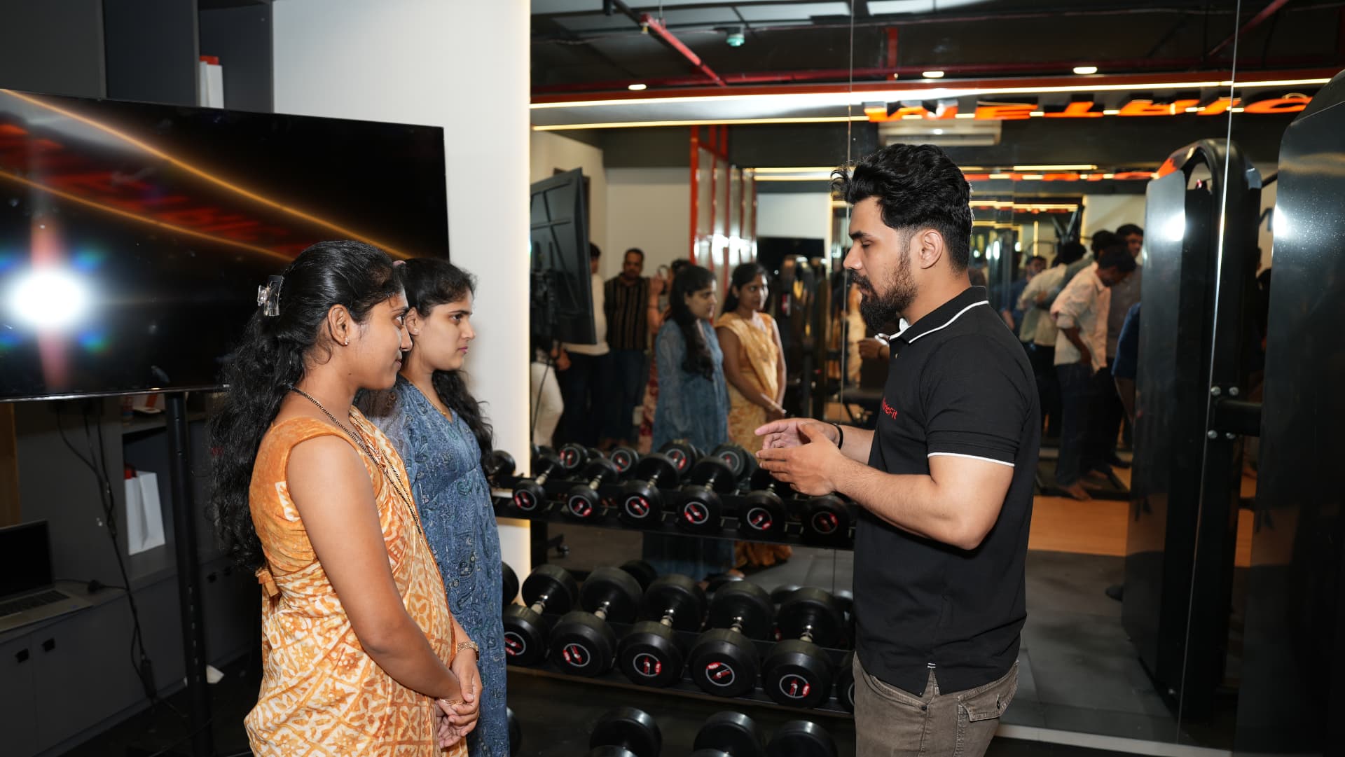 MetricFit coach explaining training guidance to two clients at the studio